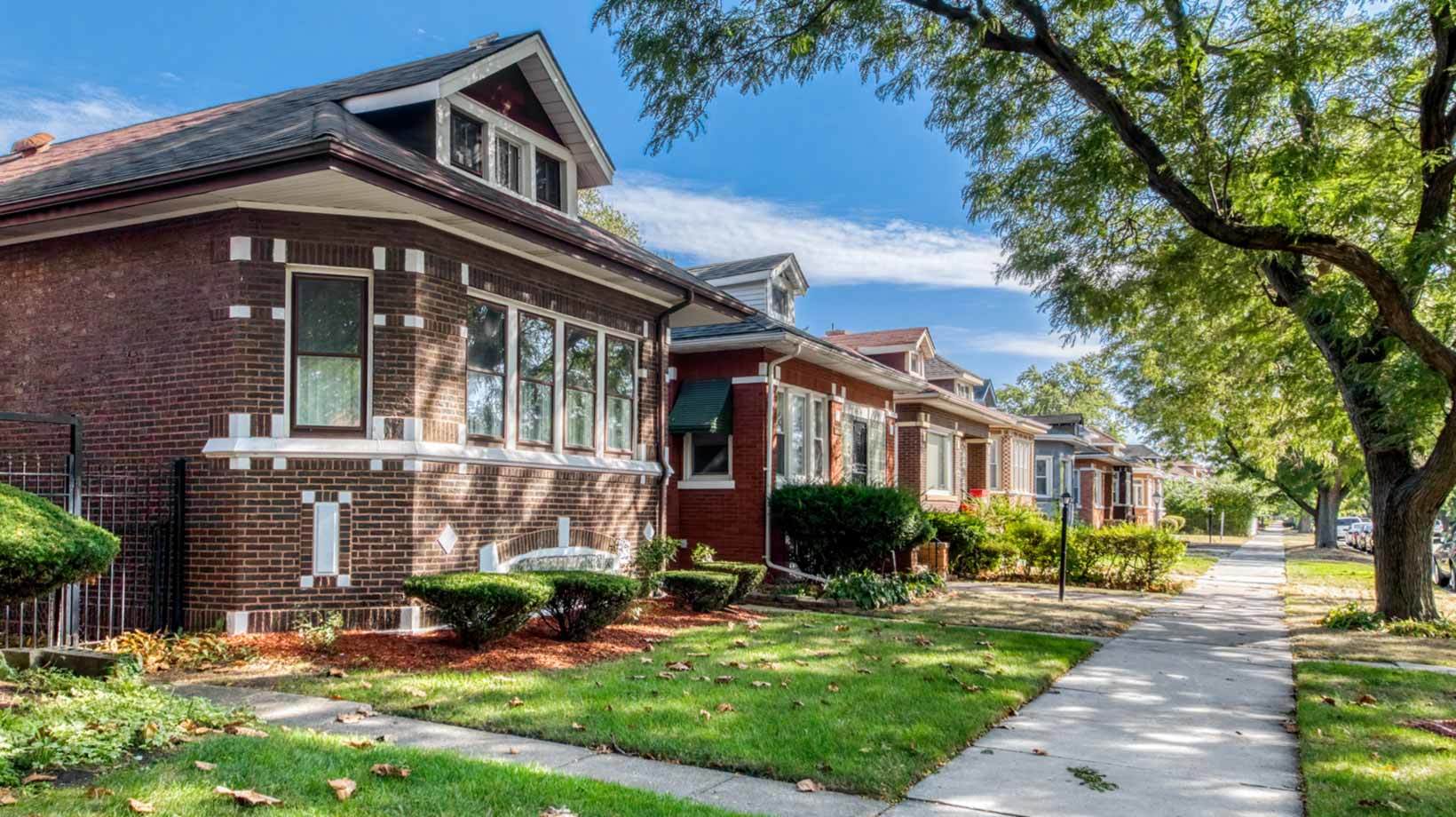 A row of houses with trees and grass.